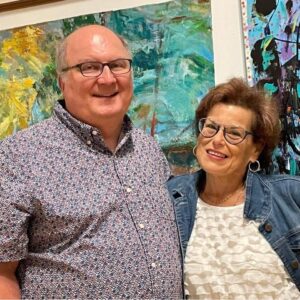Mary Joy and her husband standing in front of artwork at Hallwalls.